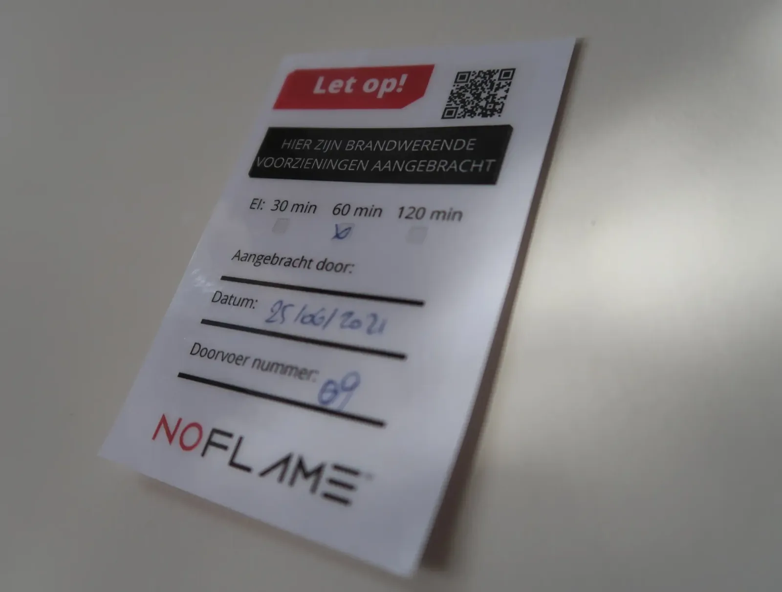 No Flame-label: Let op! Hier zijn brandwerende voorzieningen aangebracht, met EI-klasse, datum en doorvoernummer
